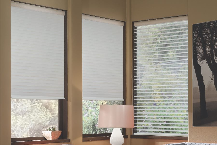 Opaque motorized window shades in Hartford keep hot UV rays out of your home. Gray motorized sheer shades on corner windows next to gray furniture