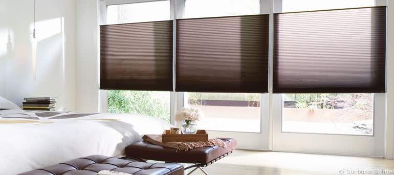 Minimal Hartford bedroom with high ceiling windows and brown honeycomb shades.