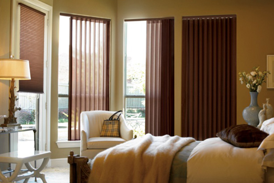 Choose durable and high-quality fabric or vinyl vertical blinds in Hartford. Maroon fabric vertical blinds inside a bedroom