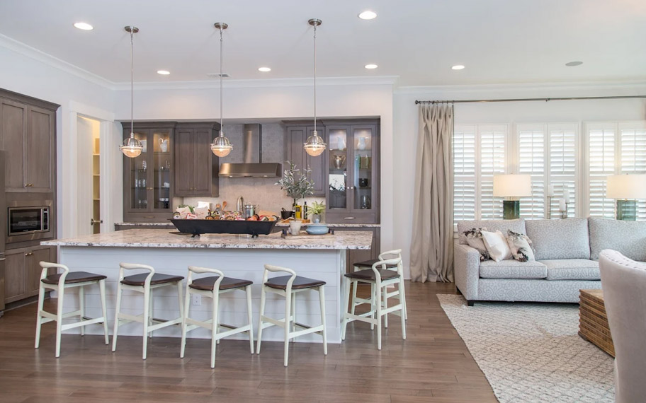 Illuminate your home with custom interior shutters in Hartford. White arched shutters in a white kitchen with lots of light.
