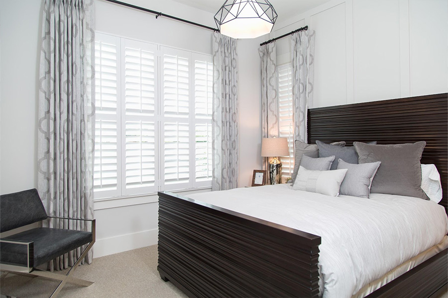 White Polywood shutters in a bedroom.