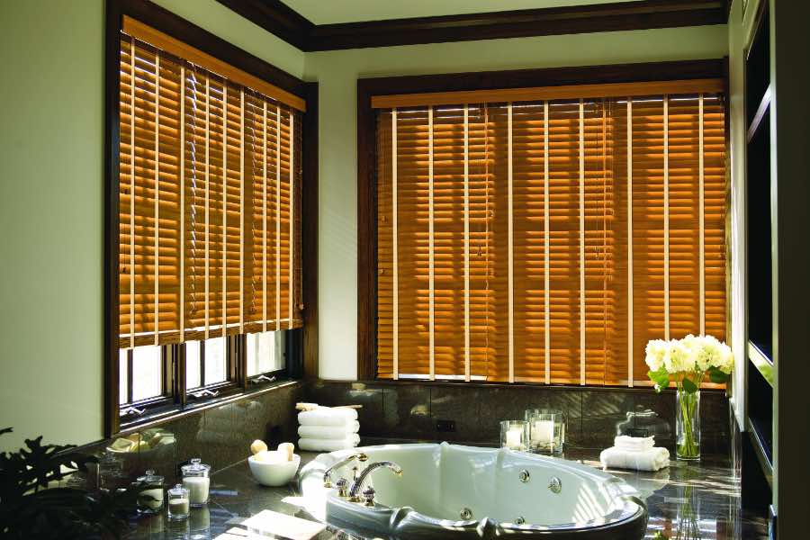 Premium quality blinds are always a stylish accent in your Hartford home. Brown wood blinds on large windows in a green bathroom