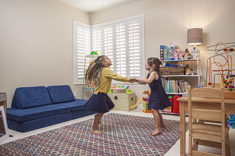 Choose Polywood shutters for durable, kid-friendly great room window treatments in Hartford. Polywood shutters on multiple windows in a sitting area