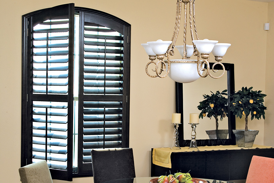 For a dark and sleek interior style, choose Ovation shutters to complete the look. Dark wood Ovation shutters in a small dining room area.