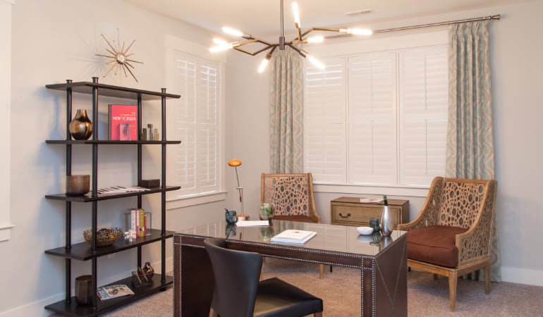 Picking the right window treatments can result in an increase in natural light. Hartford home office with plantation shutters.