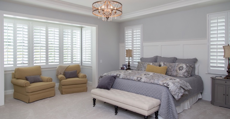 Indoor shutters offer subtle style. White shutters in Hartford bedroom.