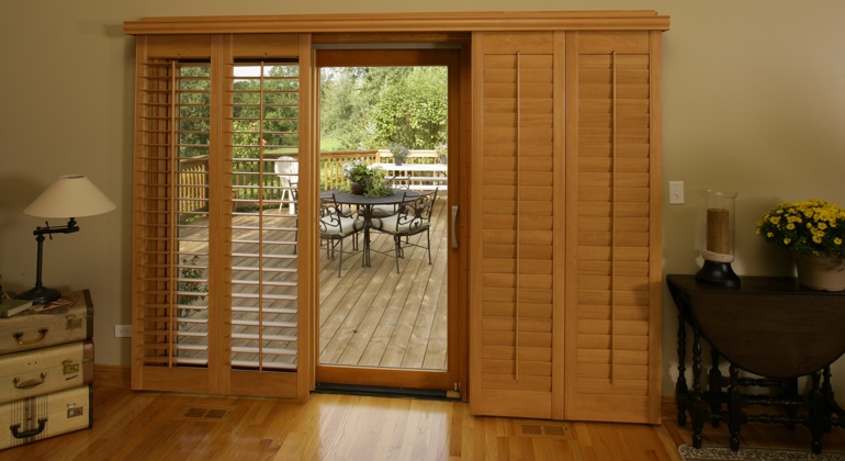 Wood shutters create a buffer that transitions from indoor wood to patio. Hartford wood shutter sliding door