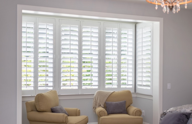North-South windows can have energy efficiency problems rather than problems with sun glare. White plantation shutters in sitting area