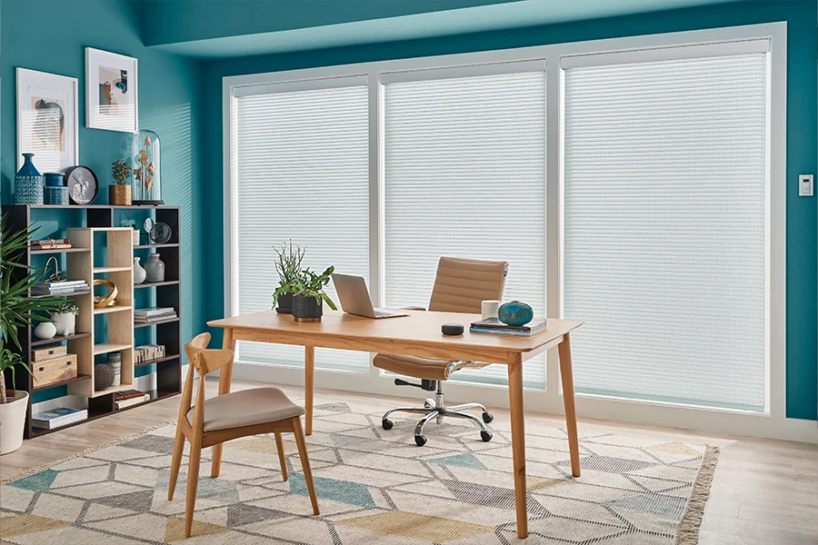 White sheer shades on large windows in a home office