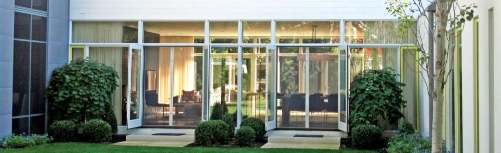 Retractable screen shades onto a garden area from a living room view