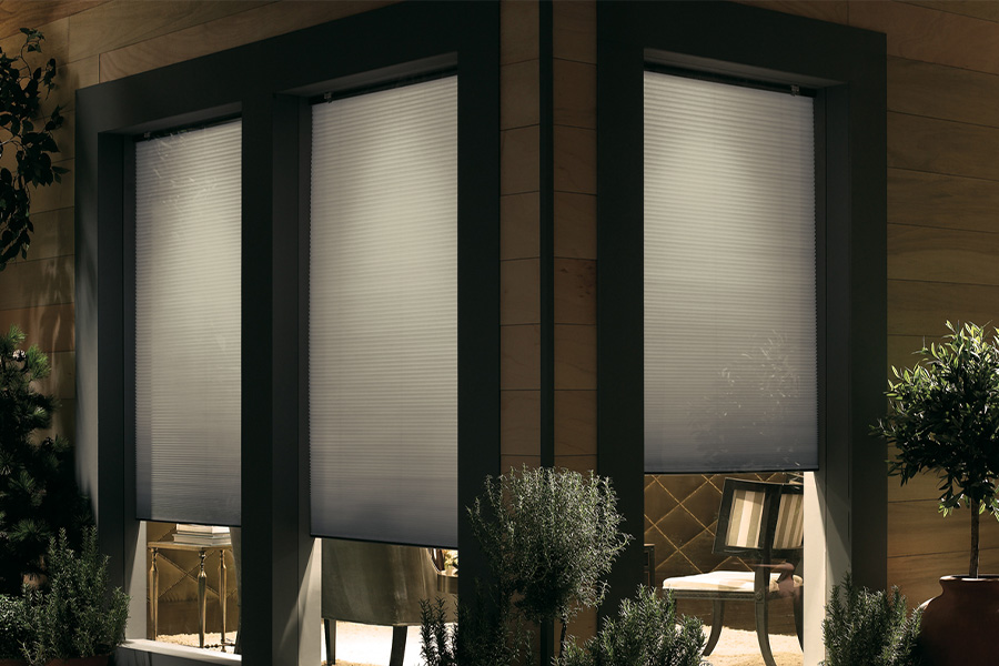 Cellular shades are modern and stylish window treatments for your home in Hartford. Dark gray cellular shades displayed from the exterior of a home.