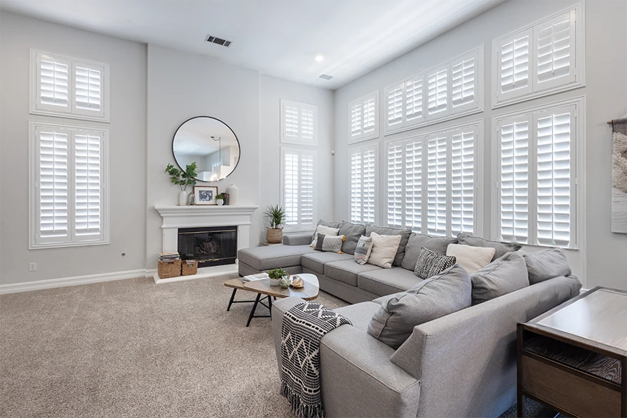Whether you're covering one window or several, a few factors will determine the final cost of your shutters. White Polywood shutters on living room windows